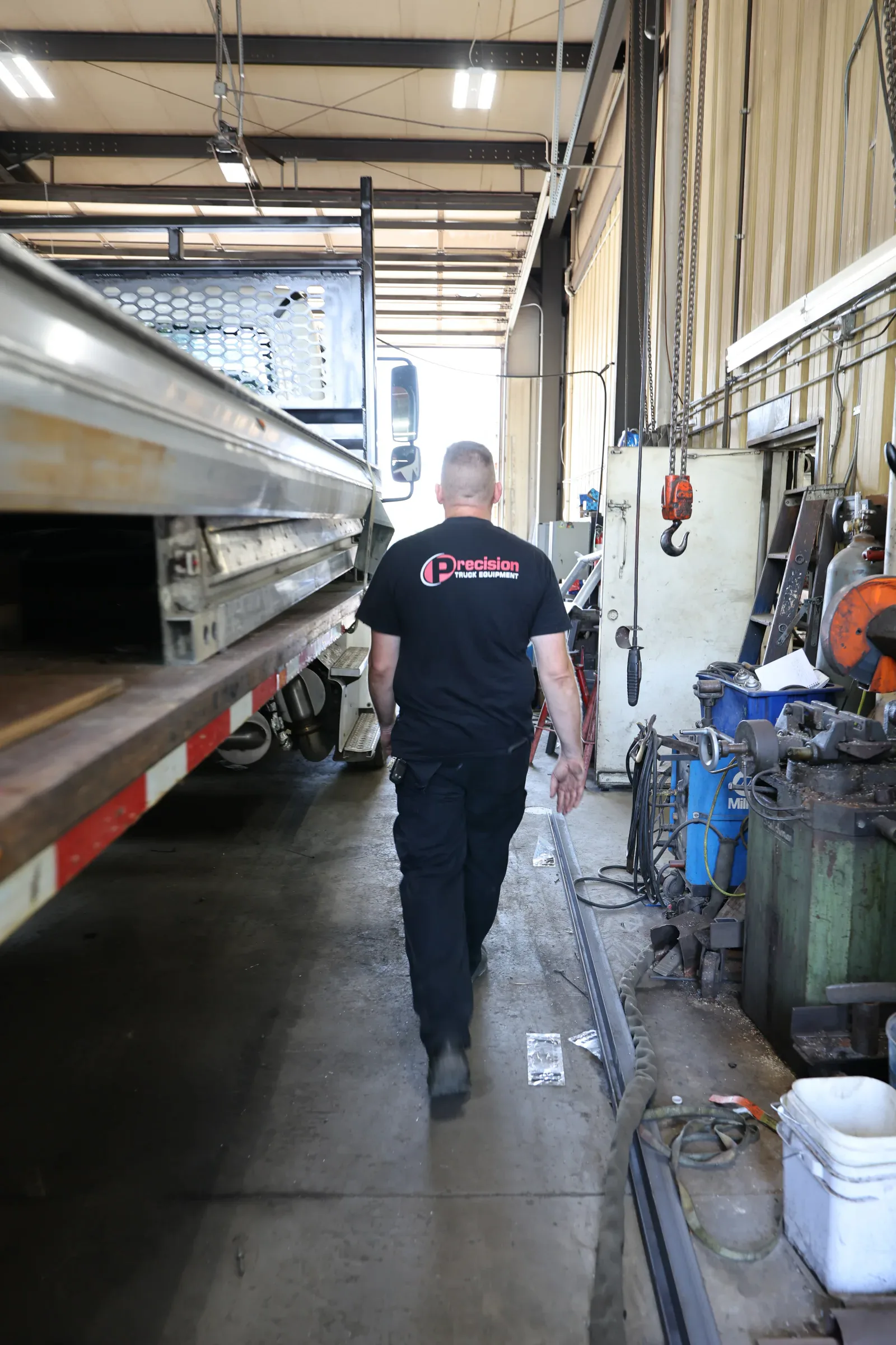 Precision Truck Equipment team member walking through the installation shop