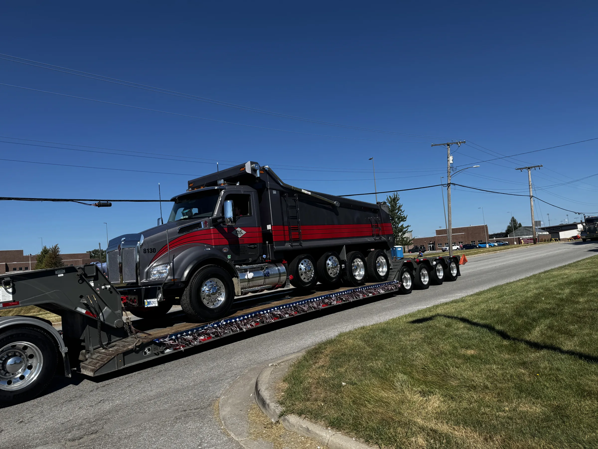 Black and red dump truck on a transport trailer